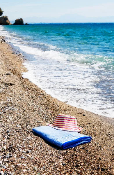 Turquoise sea,sun hat and towel. — Stock Photo, Image