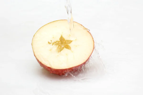 Crystal, clean water splashing on an ripe apple. — Stock Photo, Image