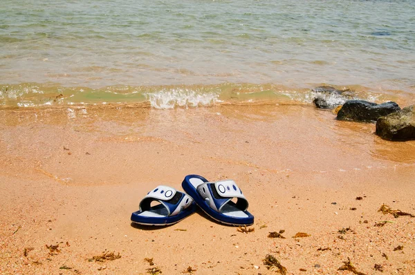 Verlassene blaue Sandale am Meer. — Stockfoto