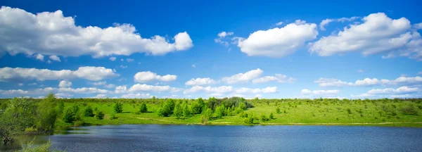 Panorama de lago, prado e céu azul . — Fotografia de Stock