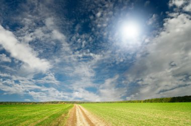 Splendid cumulus clouds and autumn field. clipart