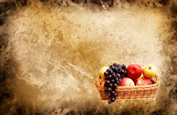 Maravillosa cesta llena de frutas de otoño sobre un fondo grunge — Foto de Stock