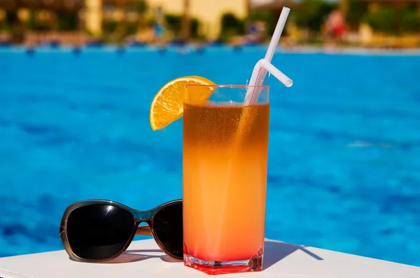 Glas velsmagende juice med rør og solbriller . - Stock-foto