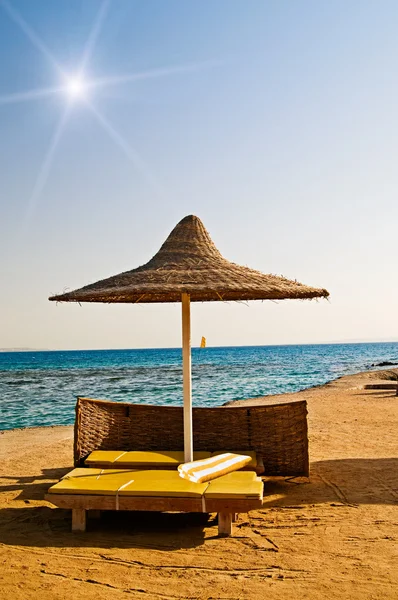 Verlaten parasol en gele handdoek op het resort. — Stockfoto