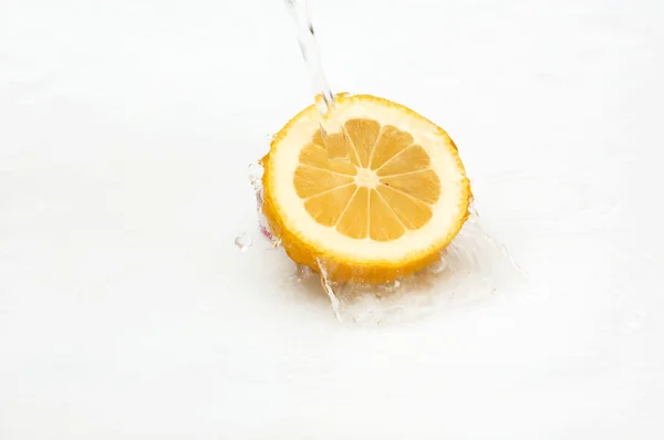 Water splash on a fresh,juicy lemon. — Stock Photo, Image