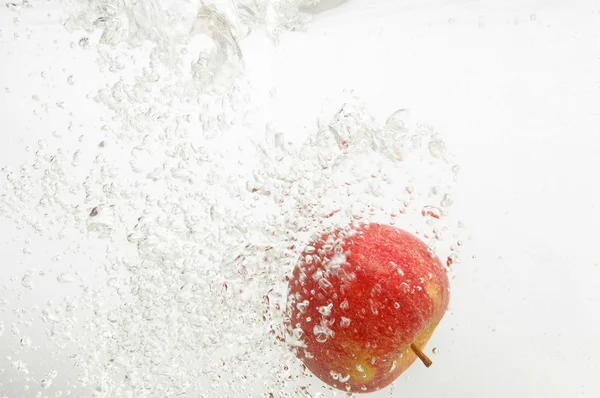 Ein Apfel wird ins Wasser geworfen. — Stockfoto