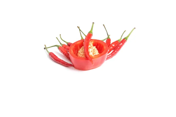 Een rode uitgesneden peper en verschillende kleine op een wit — Stockfoto