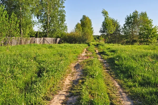 Land onverharde weg op de rand van een dorp — Stockfoto