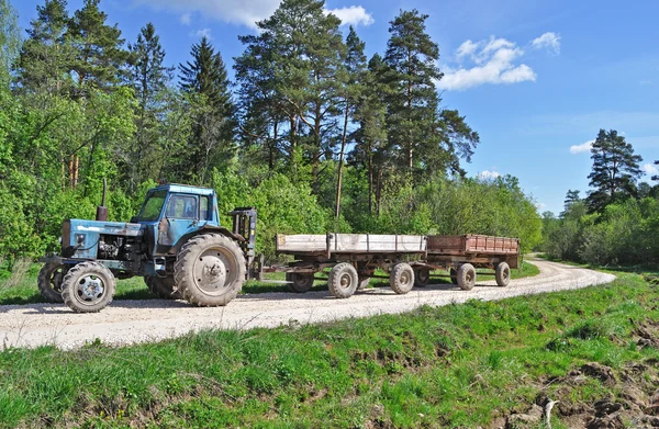 Trator com reboque na estrada de campo — Fotografia de Stock