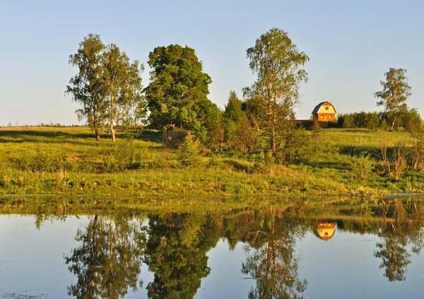 Orilla del lago con casa pequeña — Foto de Stock