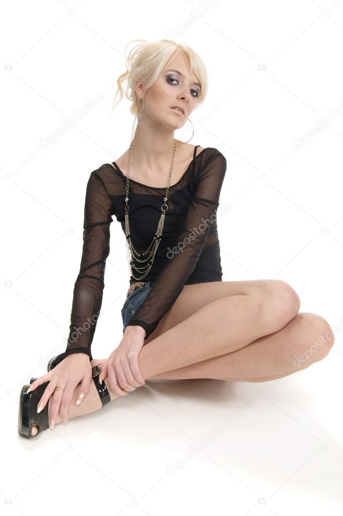 Attractive blonde young lady posing on the floor in studio over