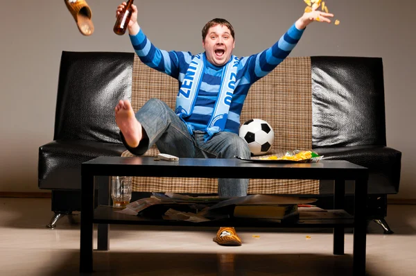 Футбольный болельщик на диване — стоковое фото