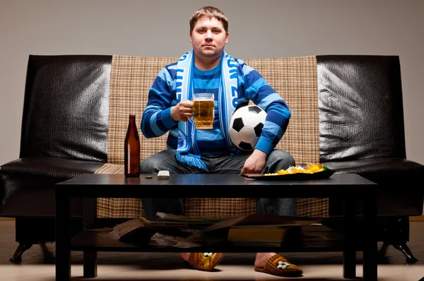 Футбольний вентилятор на дивані — стокове фото