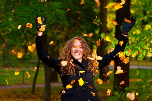 Jogando folhas de outono secas no parque — Fotografia de Stock