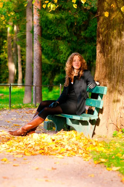 Sentado no banco no parque de outono — Fotografia de Stock