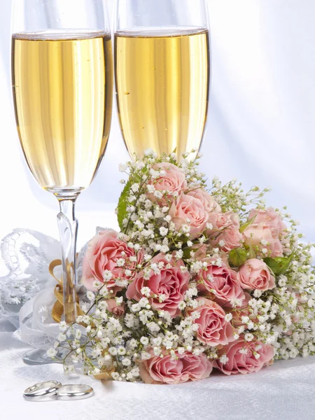 Dvě sklenky s šampaňským a kytice růží — Stock fotografie