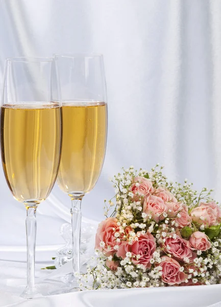 Dwa kieliszki do szampana i bukiet róż — Zdjęcie stockowe