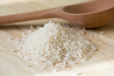 Rice grains and empty wooden spoon clipart