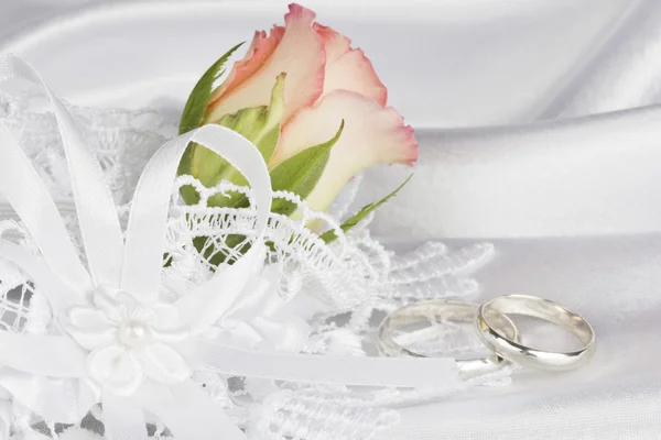 Branco de seda com um laço e rosa — Fotografia de Stock