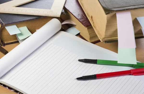 Opened notebook, old books, pens — Stock Photo, Image