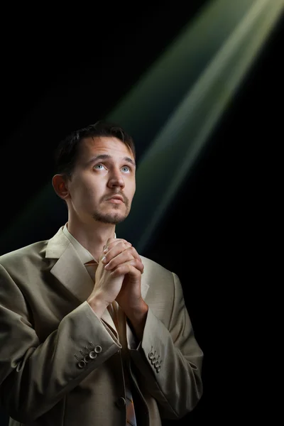 stock image Young man in a suit, praying for something