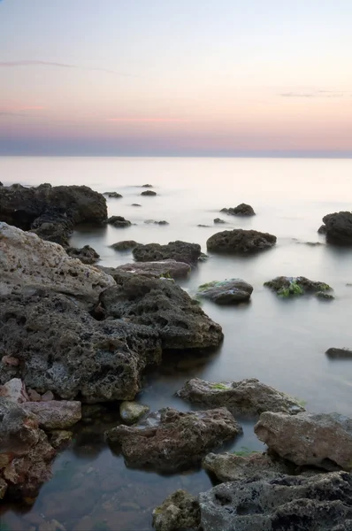 Море и скала на закате . — стоковое фото