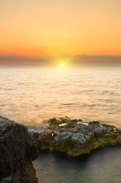 Zee en rots op de zonsondergang. — Stockfoto