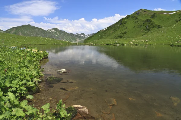 Горное озеро с отражением облаков — стоковое фото