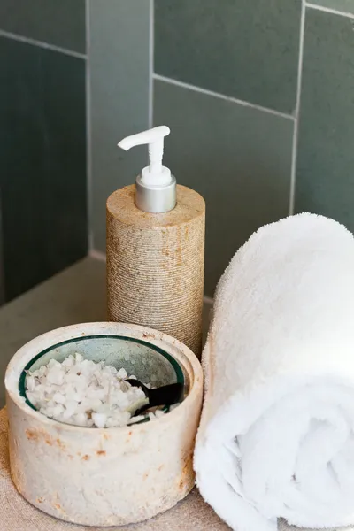 Dispenser, bath salt and towel — Stock Photo, Image