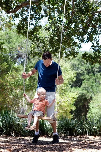 Father and son on a swing — Stock Photo, Image