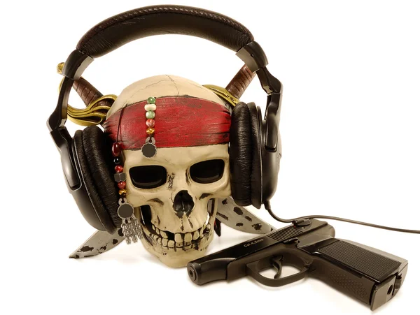 Schädel in Ohrhörer mit liegender Pistole — Stockfoto