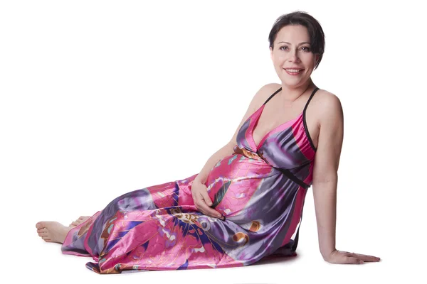 Těhotná žena leží v krásné šaty — Stock fotografie
