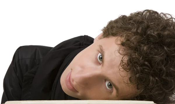 The young man with curly hair has bent to a table — Stock Photo, Image