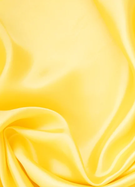 Гладкий элегантный золотой шелк в качестве фона — стоковое фото