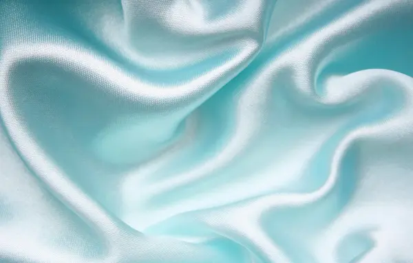 Гладкий элегантный синий шелк в качестве фона — стоковое фото