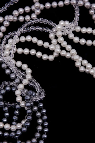Weiße und schwarze Perlen auf der schwarzen Seide — Stockfoto