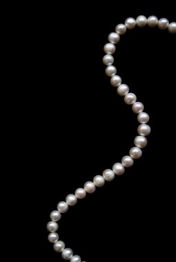 White pearls on the black silk as background clipart