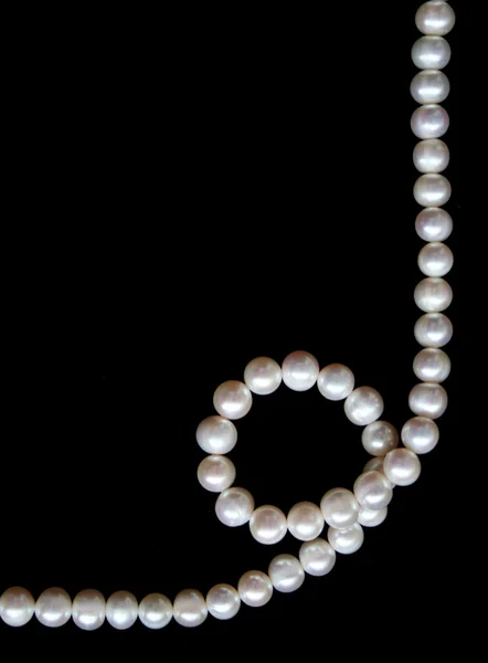 Weiße Perlen auf der schwarzen Seide als Hintergrund — Stockfoto
