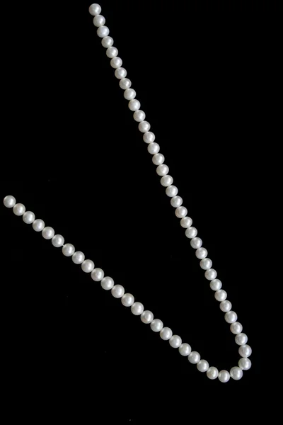 Białe perły na czarny aksamit — Zdjęcie stockowe