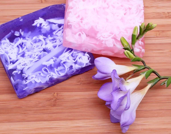 Jabón lila y rosa sobre fondo de madera en una composición de spa — Foto de Stock