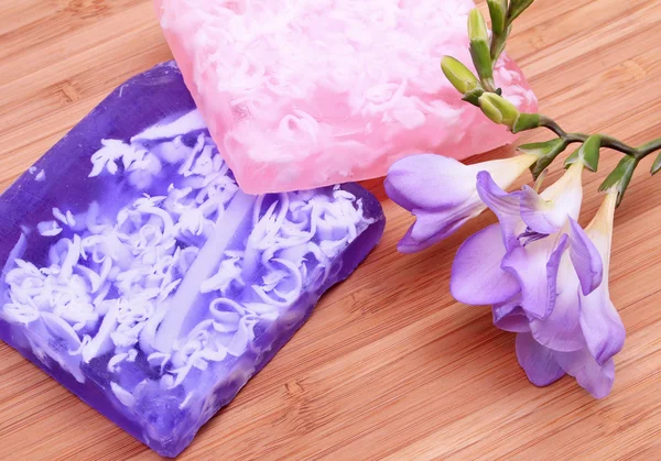 Jabón lila y rosa sobre fondo de madera en una composición de spa —  Fotos de Stock