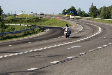 A motorcyclist going on a highway clipart