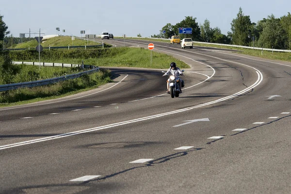 Un motociclista que va por una carretera — Foto de Stock
