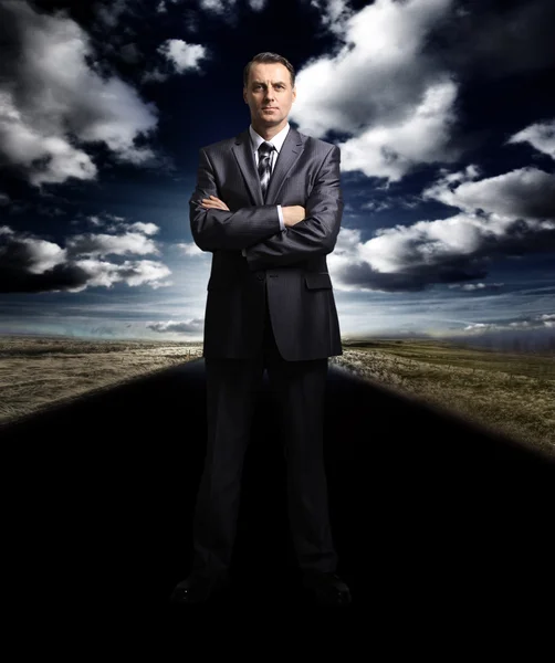 Business man standing on the road — Stock Photo, Image