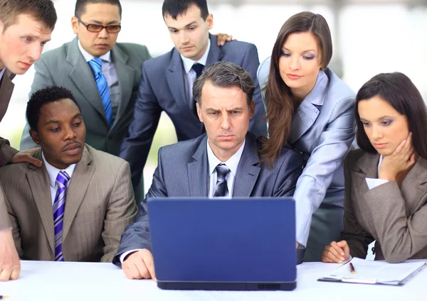 Equipe de negócios inter-racial trabalhando no laptop em um escritório moderno — Fotografia de Stock