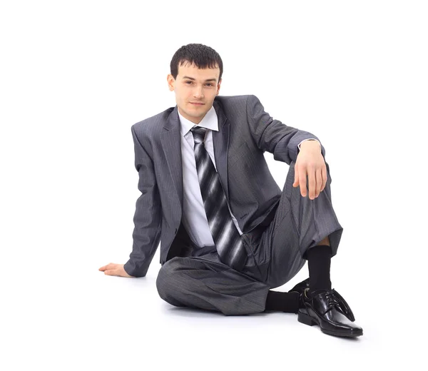 Bonito homem de negócios sentado no chão. Isolado sobre fundo branco — Fotografia de Stock
