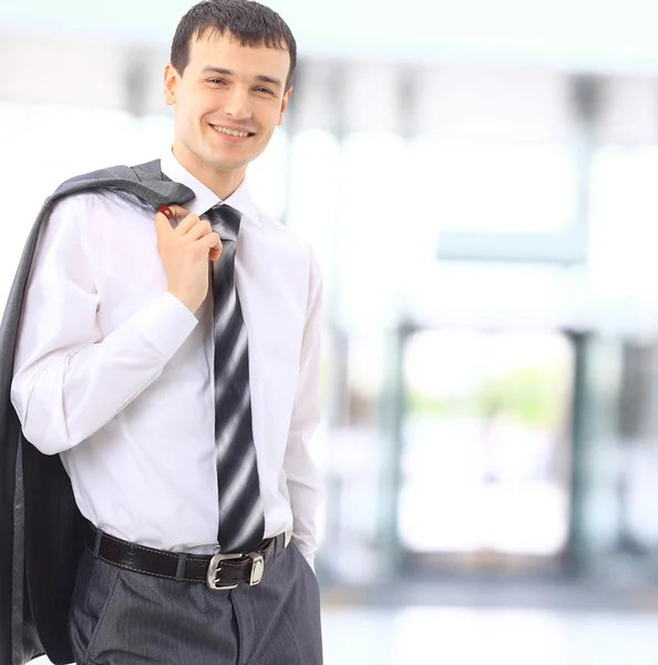Χαμογελαστός άνθρωπος των επιχειρήσεων στέκεται σε ένα σύγχρονο γραφείο — Φωτογραφία Αρχείου