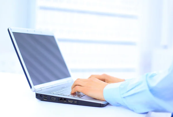 Pessoa digitando em um laptop moderno em um escritório — Fotografia de Stock
