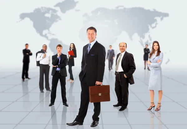 Businessmen standing in front of an earth map Stock Photo