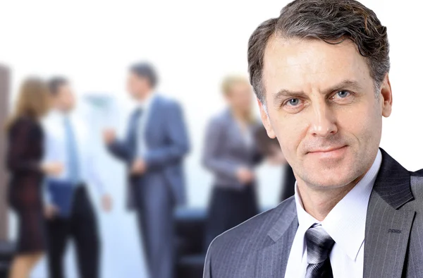 Uomo d'affari di successo in piedi con il suo personale in background in ufficio — Foto Stock